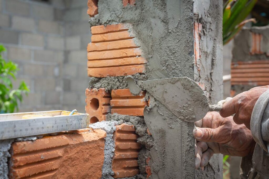 Bricklaying construction worker building brick wall
